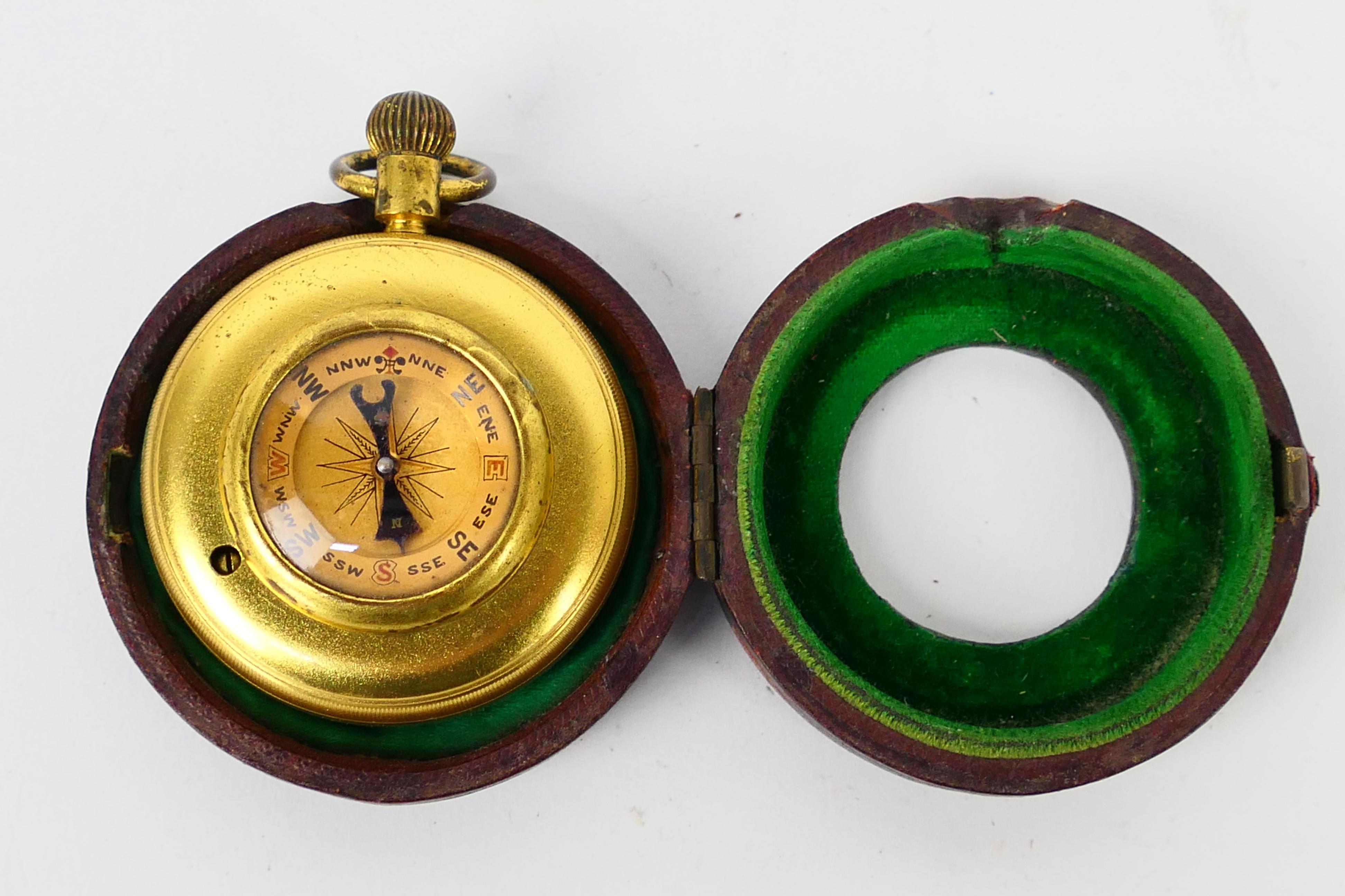 A Chadburn & Son gilt brass cased pocket barometer / compass contained in leather case.