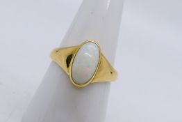 A yellow metal ring presumed 18 ct gold set with single white oval opal cabochon, size O+½,