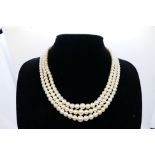 A lady's three-strand seed pearl necklace with 9 ct sapphire and seed pearl set clasp,