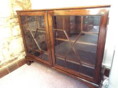 A period display cabinet with astral glazed twin doors opening to reveal a shelved interior,