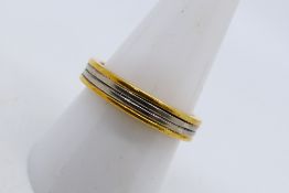 An 18ct two tone gold band ring, size Q+½, approximately 7.1 grams.