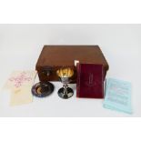 A silver plated communion set and book of common prayer contained in case.