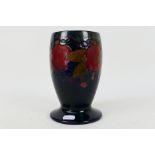 Moorcroft Pottery - A pomegranate pattern vase of footed ovoid barrel form,