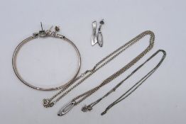 A silver bangle, a white metal (stamped 925) and diamond pendant on 925 stamped chain,