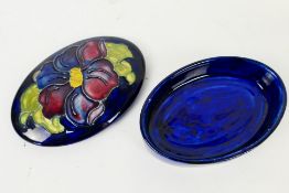 Moorcroft Pottery - An oval lidded pot in the hibiscus pattern against a blue ground and the base