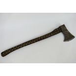 A vintage French axe, the head marked Peugeot Freres, the handle leather bound with stud work,