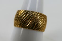 A 9ct yellow gold textured band ring, size N+½, approximately 5.