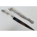 An Argentinian white metal Gaucho knife with floral decorated hilt and scabbard,