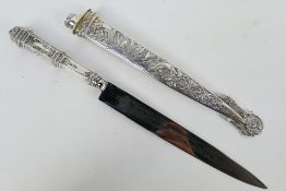 An Argentinian white metal Gaucho knife with floral decorated hilt and scabbard,
