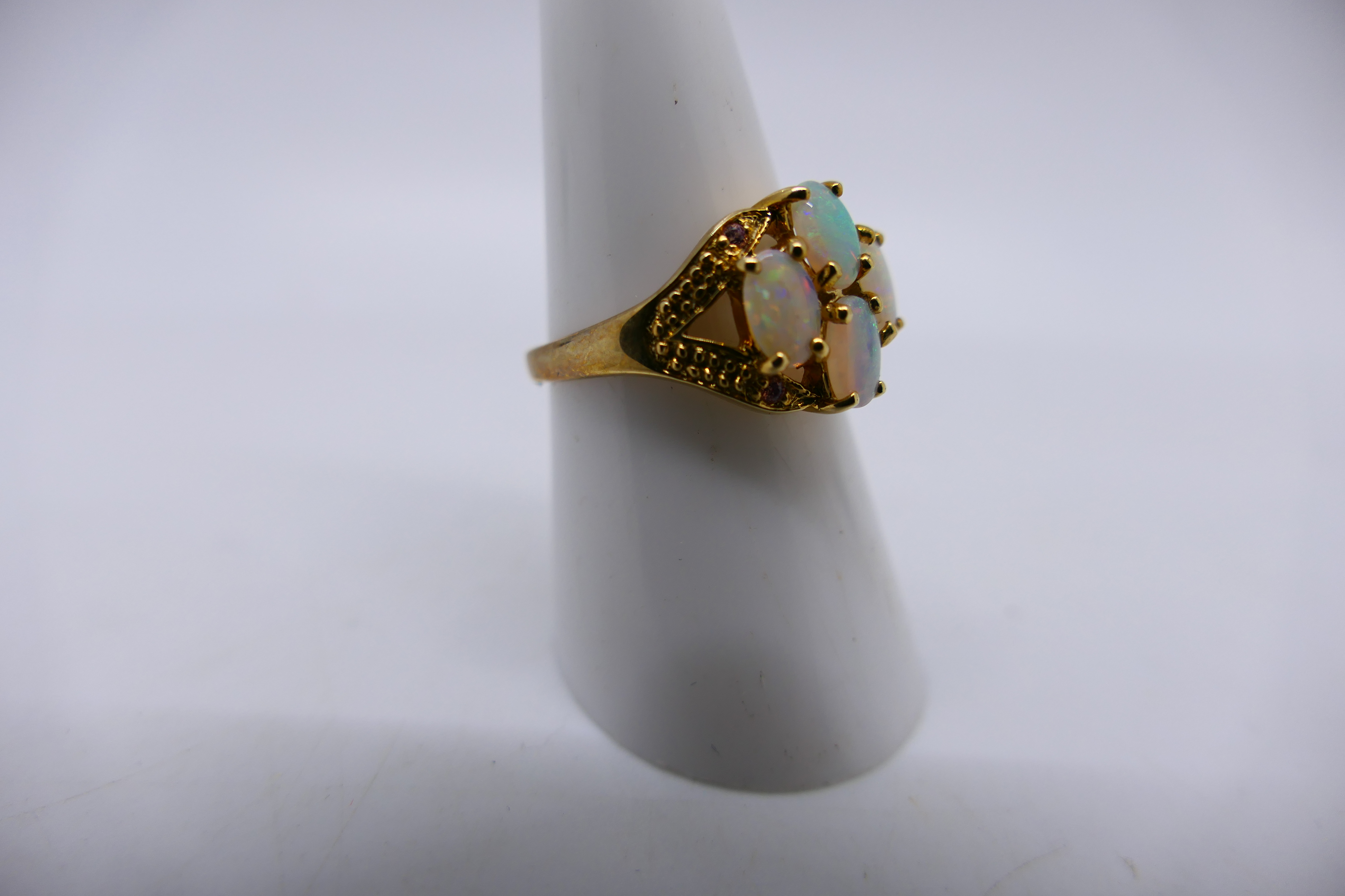 A 9ct yellow gold ring set with four white opal cabochons, size N and a yellow metal, - Image 2 of 5