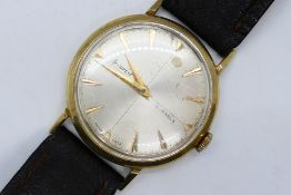 A gentleman's 9ct gold cased Accurist wrist watch on brown leather strap,