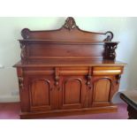 A chiffonier with three panel doors with a drawer over each and rear raised shelved back with