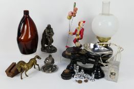 A mixed lot to include converted oil lamp, clown figure, scales, novelty table lighter and similar.