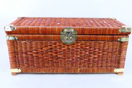 A wicker chest with decorative brassed mounts, approximately 32 cm x 71 cm x 31 cm.