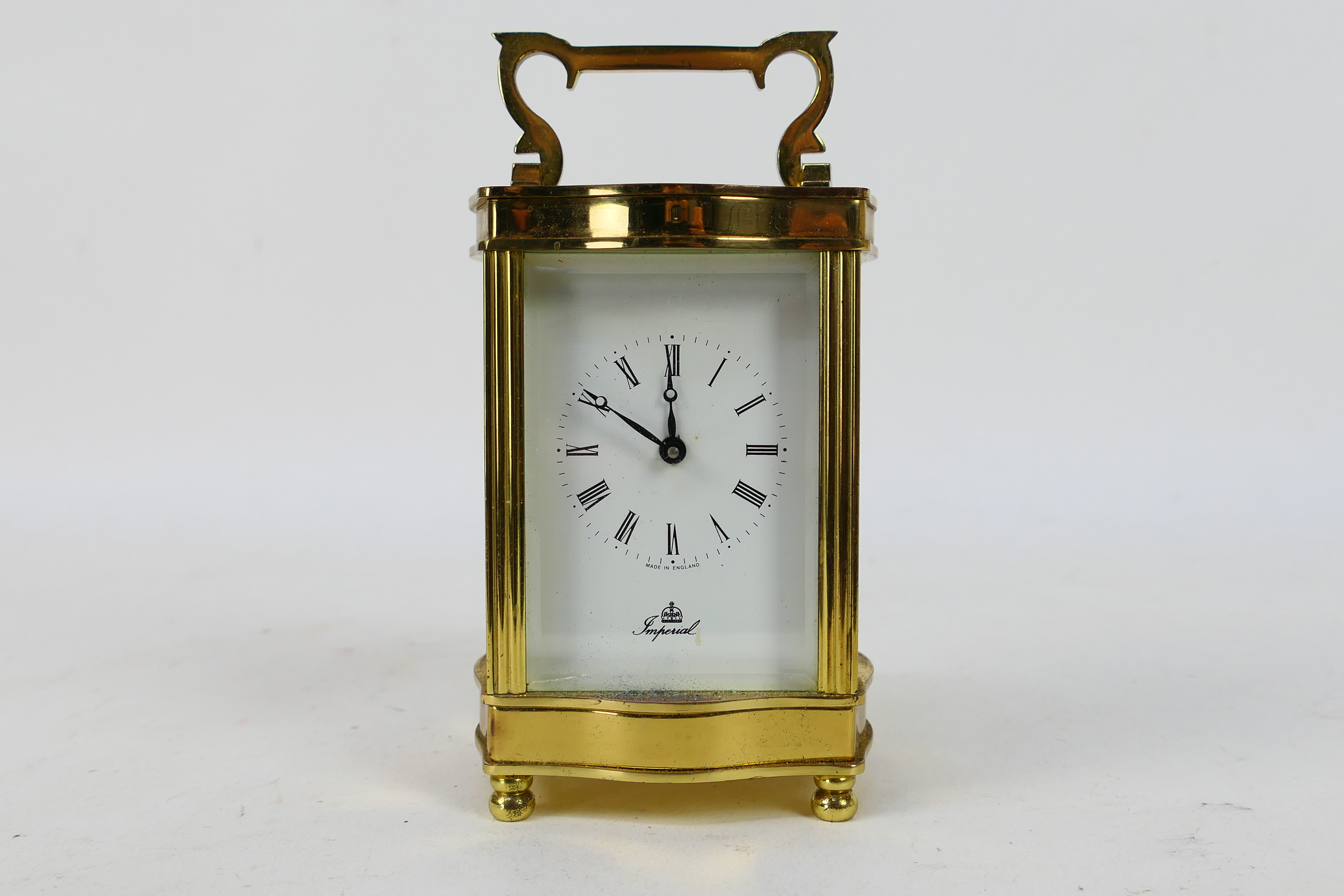 A brass and glass cased carriage clock, Roman numerals to a white dial, the dial signed Imperial,