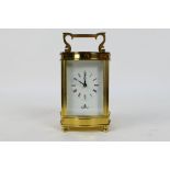 A brass and glass cased carriage clock, Roman numerals to a white dial, the dial signed Imperial,