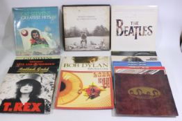 A collection of 12" vinyl records to include Bob Dylan, The Beatles, Kate Bush, The Rolling Stones,