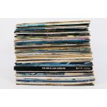 A collection of 12" vinyl records to include Elton John, Rod Stewart, ELO, Simon & Garfunkel,