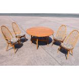 An Ercol drop leaf dining table with four Quaker dining chairs (2+2),