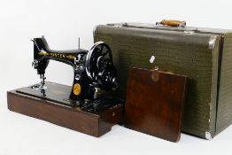 A vintage Singer ED series sewing machine contained in case.