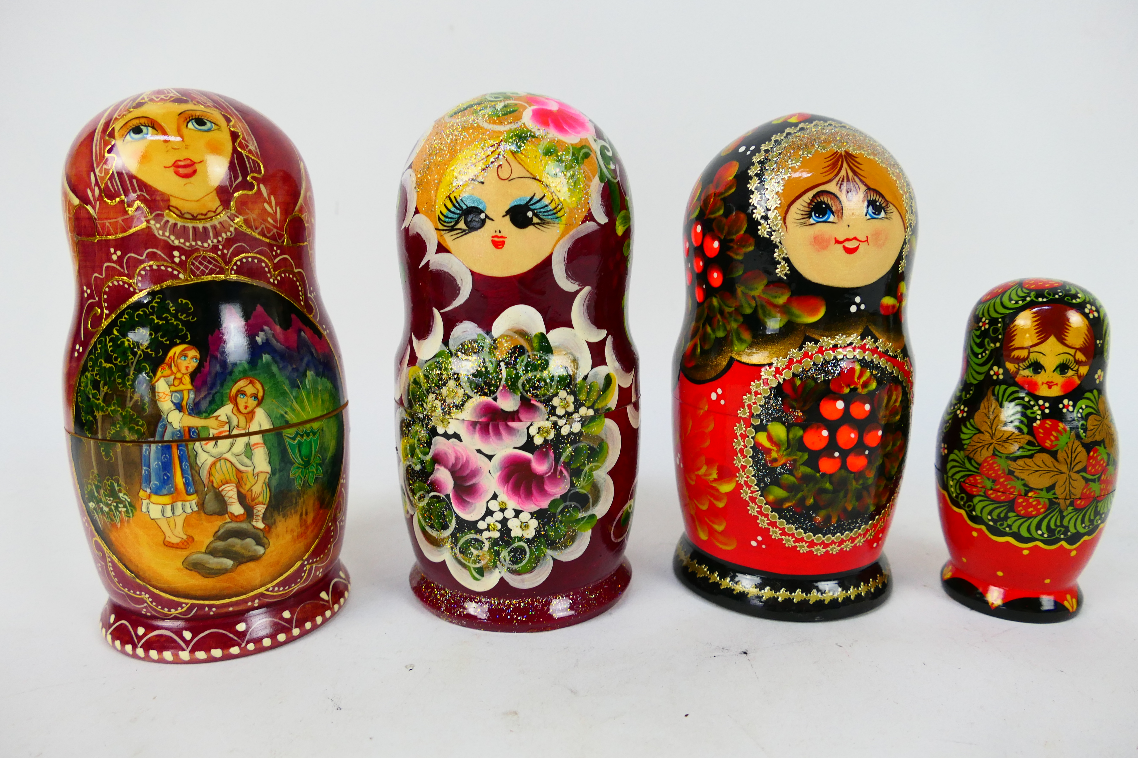 Four sets of Russian matryoshka nesting dolls, largest approximately 17 cm (h).