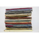 A collection of 12" vinyl records to include Rod Stewart, Simon & Garfunkel, Queen,