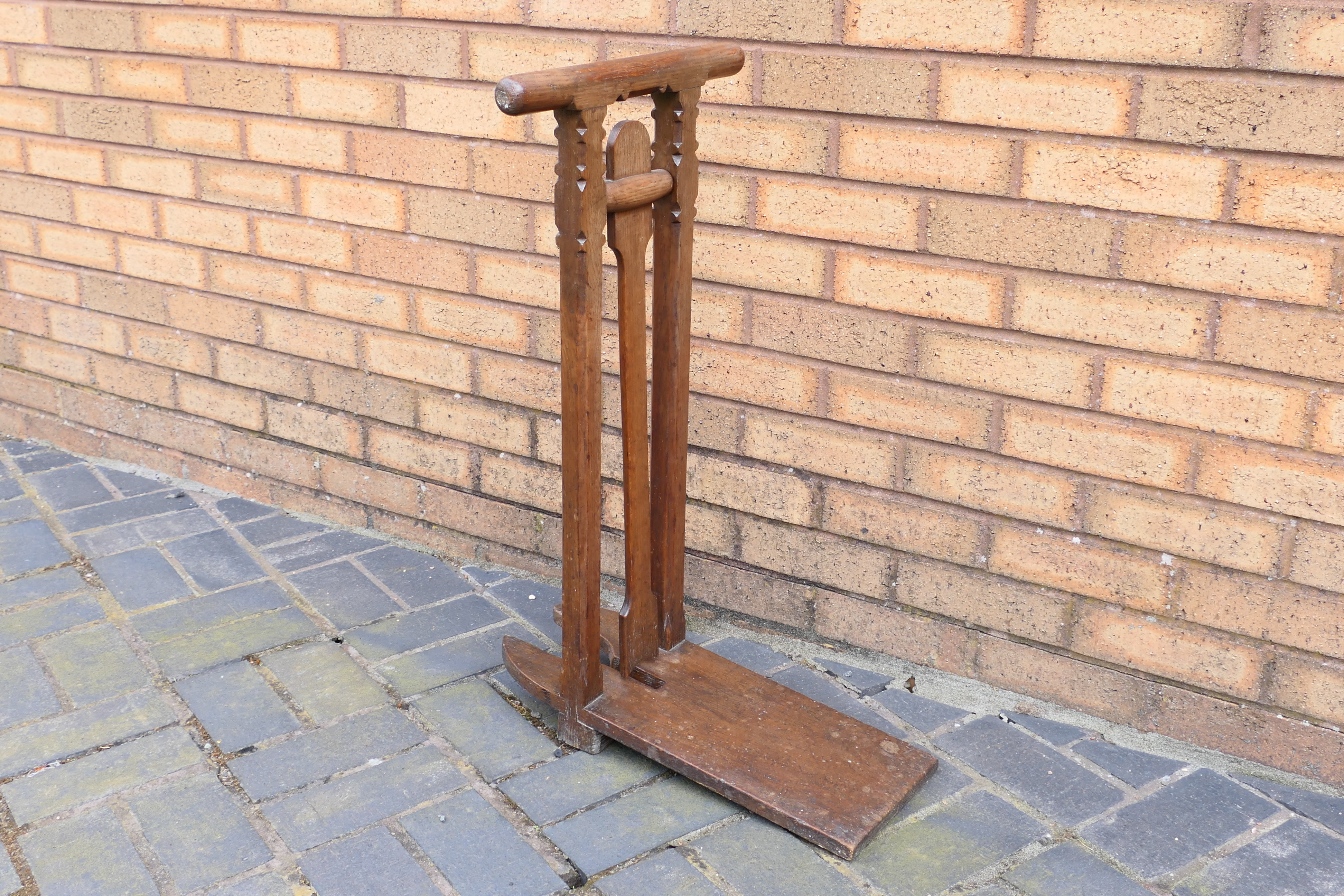 An oak boot jack with two handled top with twin columns and carved recess for boot heel,