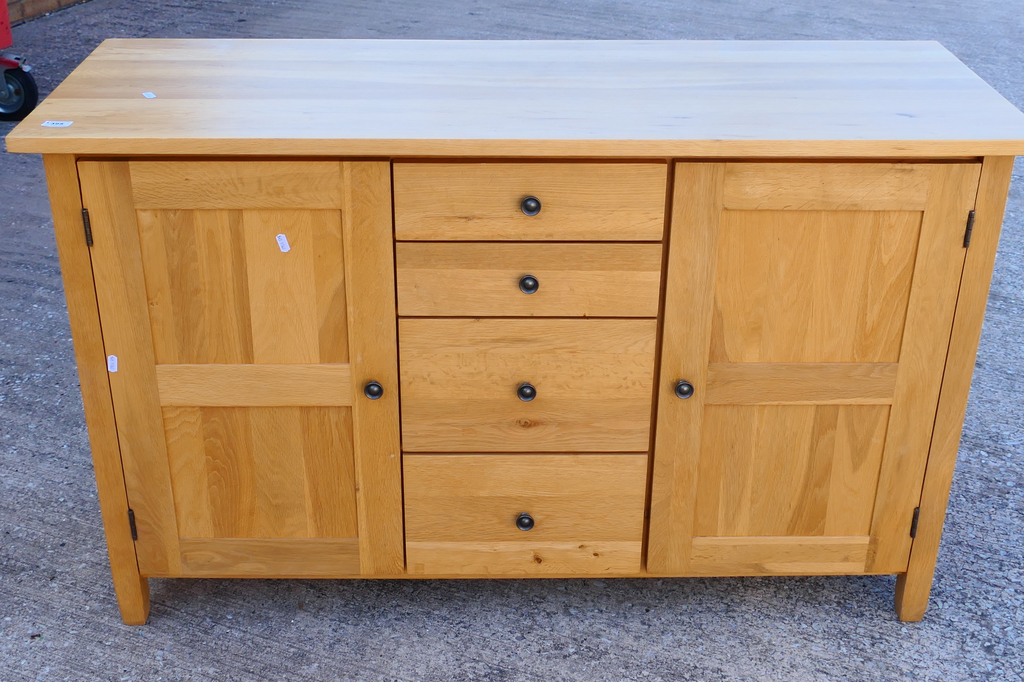 A light oak sideboard with four central, graduated drawers flanked by single door cupboards, - Image 2 of 6