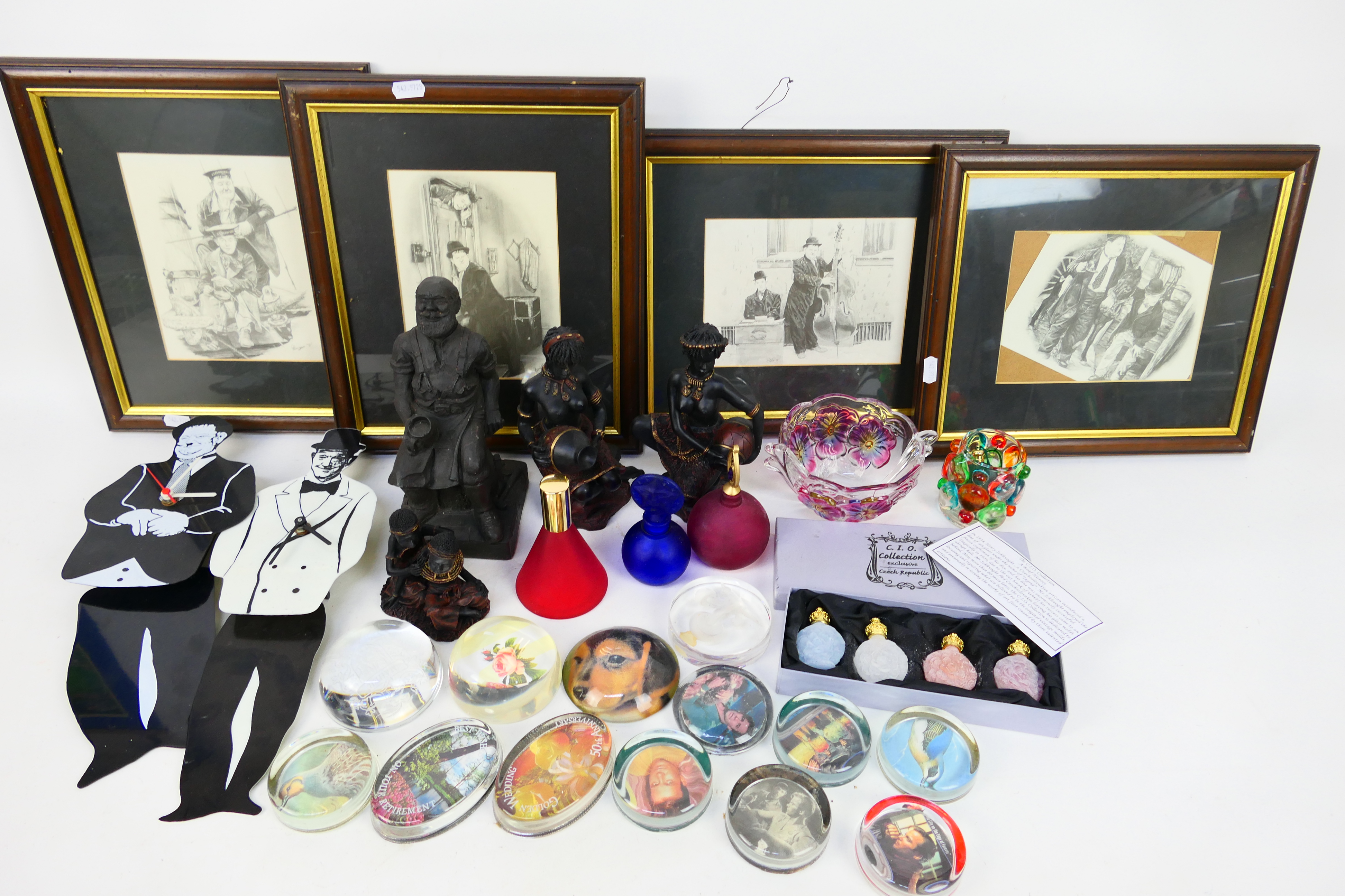 A mixed lot to include paperweights, Laurel & Hardy prints and wall clocks, various ornaments,