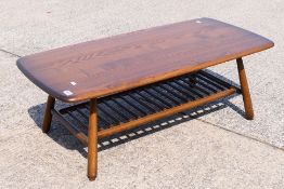 An Ercol coffee table with spindle undertier, approximately 36 cm x 104 cm x 50 cm.