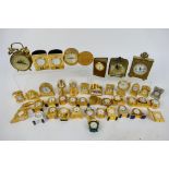 A collection of predominantly brass miniature desk clocks.