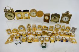 A collection of predominantly brass miniature desk clocks.