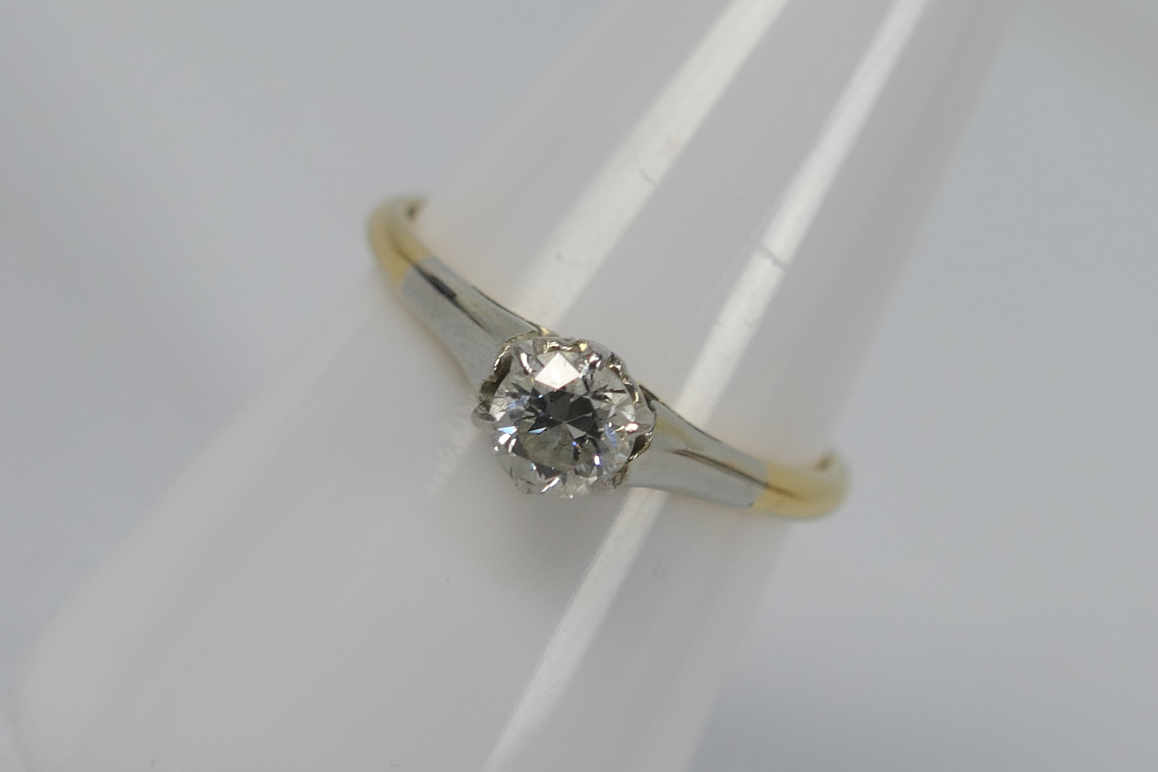 A two-tone, solitaire ring, stamped 18ct, size O, approximately 2.2 grams all in.