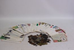 A small collection of first day covers and a quantity of UK and foreign coins / tokens.