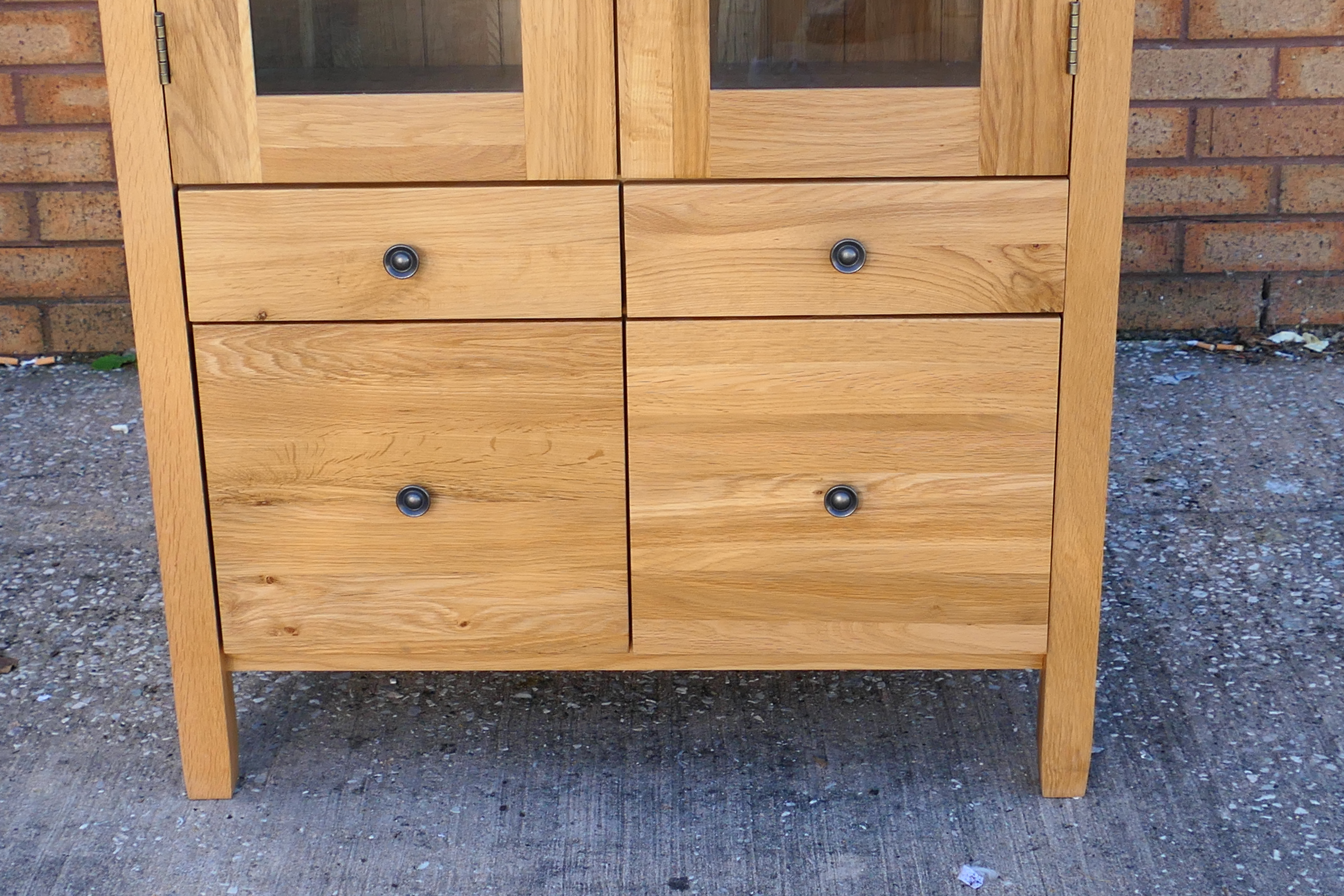 A light oak cabinet with twin glazed doors enclosing two shelves over four short drawers, - Image 2 of 4