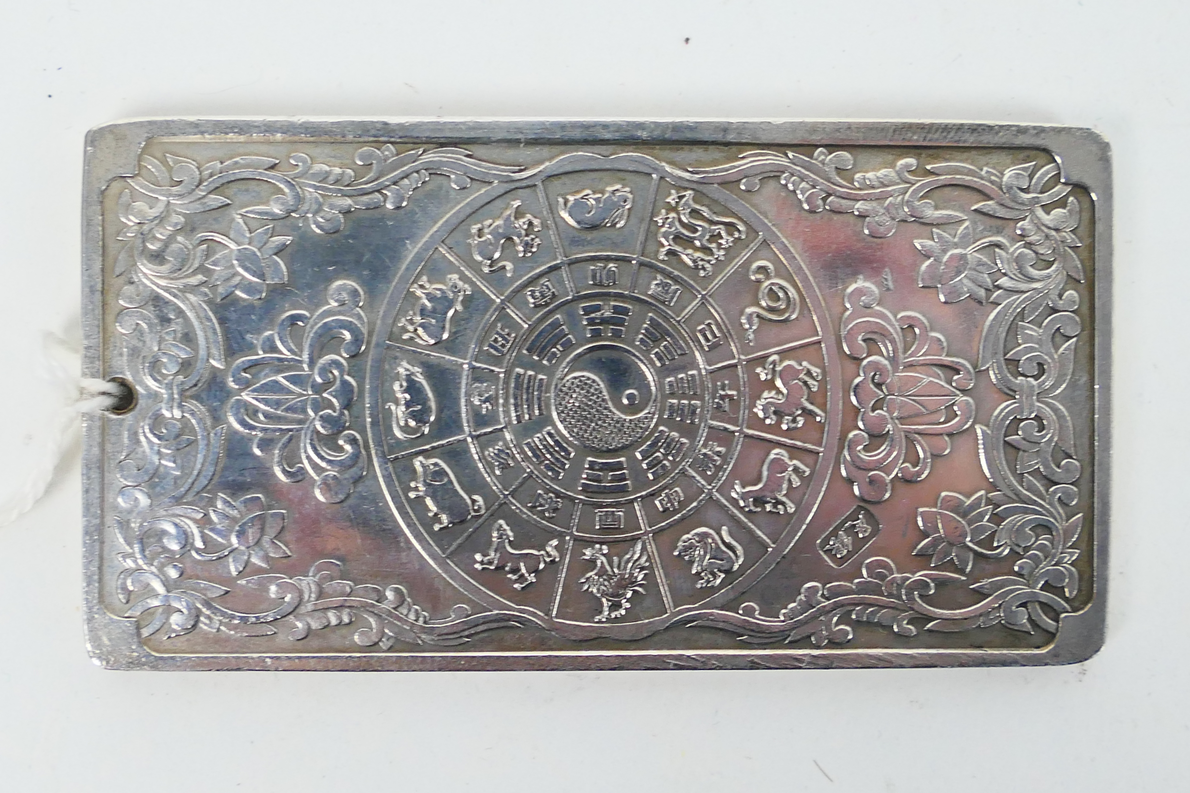 A Chinese white metal (presumed silver) ingot / plaque with depiction of a five clawed dragon to