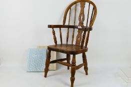 A childs windsor armchair, 75 cm (h) and a baby book.