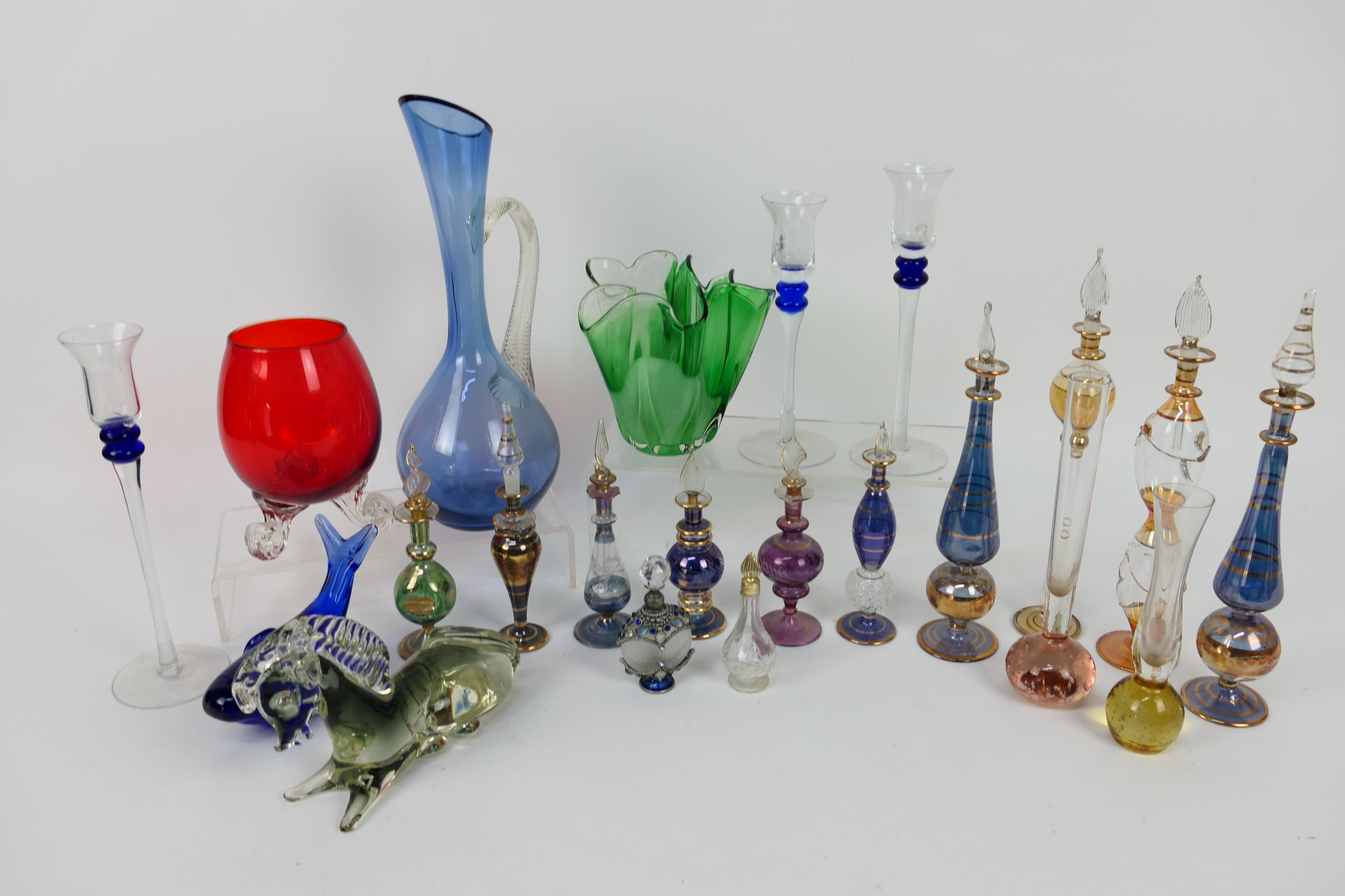 A collection of various glassware to include Egyptian perfume bottles, paperweights,