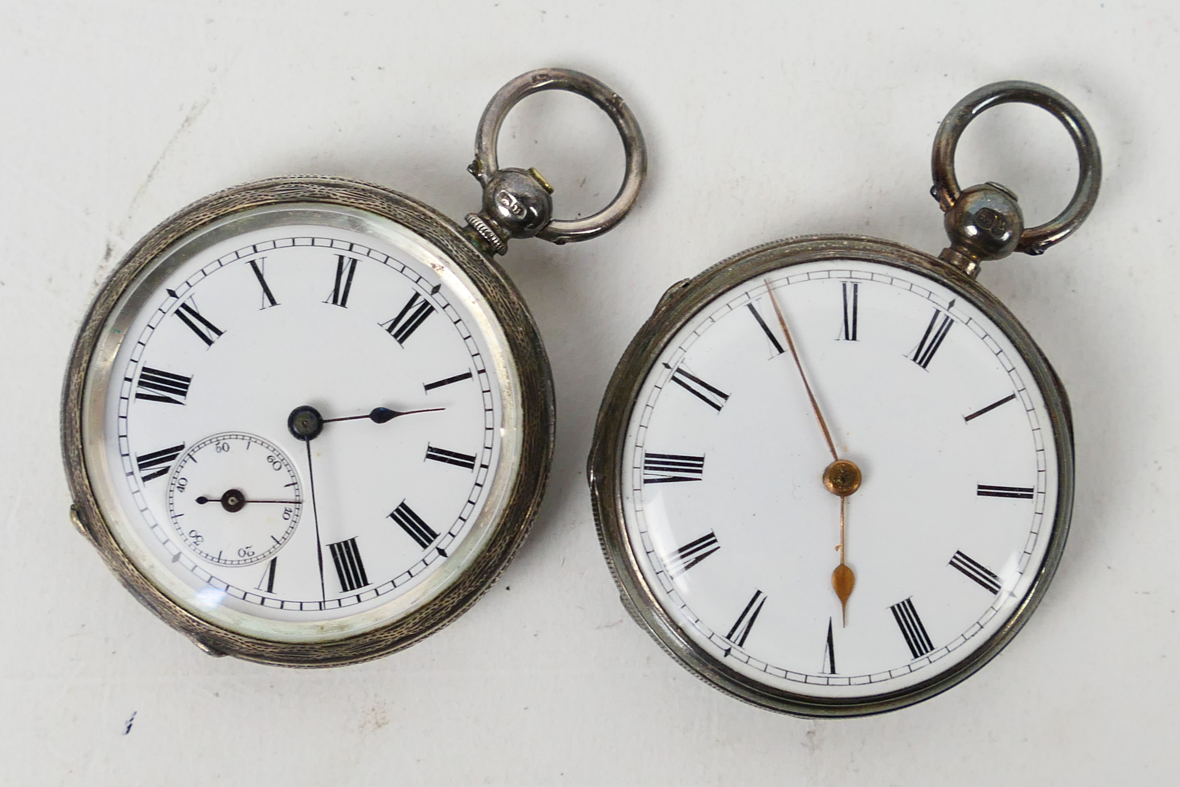Two small silver cased open face pocket watches, the first with profusely engraved case,
