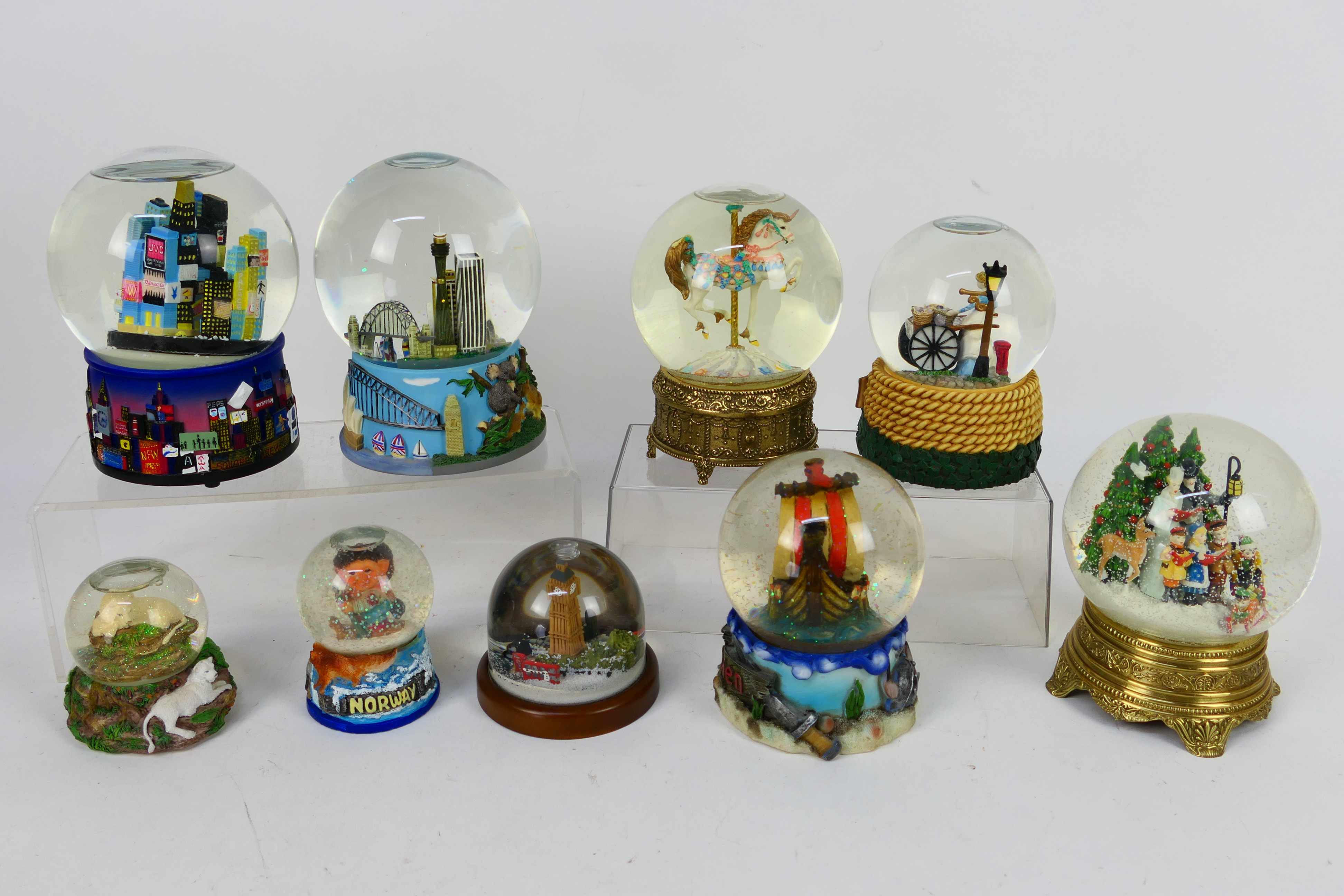 A collection of snow globes, predominantly musical, largest approximately 16 cm (h).