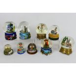 A collection of snow globes, predominantly musical, largest approximately 16 cm (h).