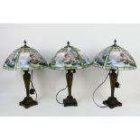 Three Tiffany style table lamps, each approximately 59 cm (h). [3].