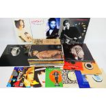 A collection of 12" and 7" vinyl records to include Paul McCartney, Elton John,