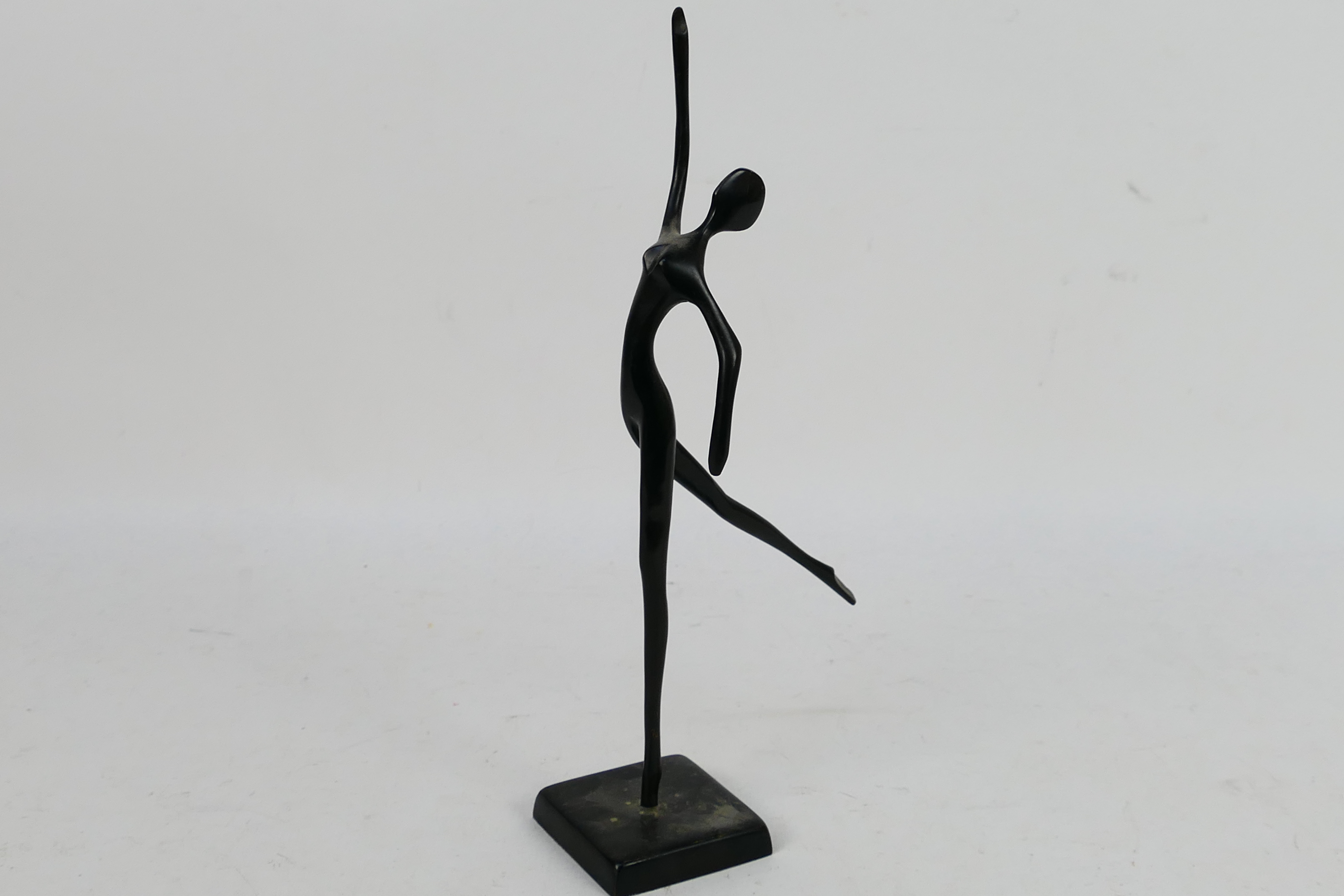 A modern bronze sculpture depicting a stylised, slender female figure 32.5 cm (h).