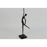 A modern bronze sculpture depicting a stylised, slender female figure 32.5 cm (h).