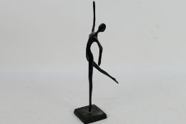 A modern bronze sculpture depicting a stylised, slender female figure 32.5 cm (h).