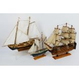 Three wooden models of sailing ships, largest approximately 43 cm x 49 cm.