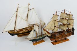 Three wooden models of sailing ships, largest approximately 43 cm x 49 cm.
