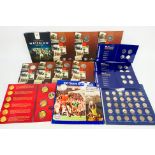A quantity of commemorative coin collector wallets, each containing the initial coin of issue,