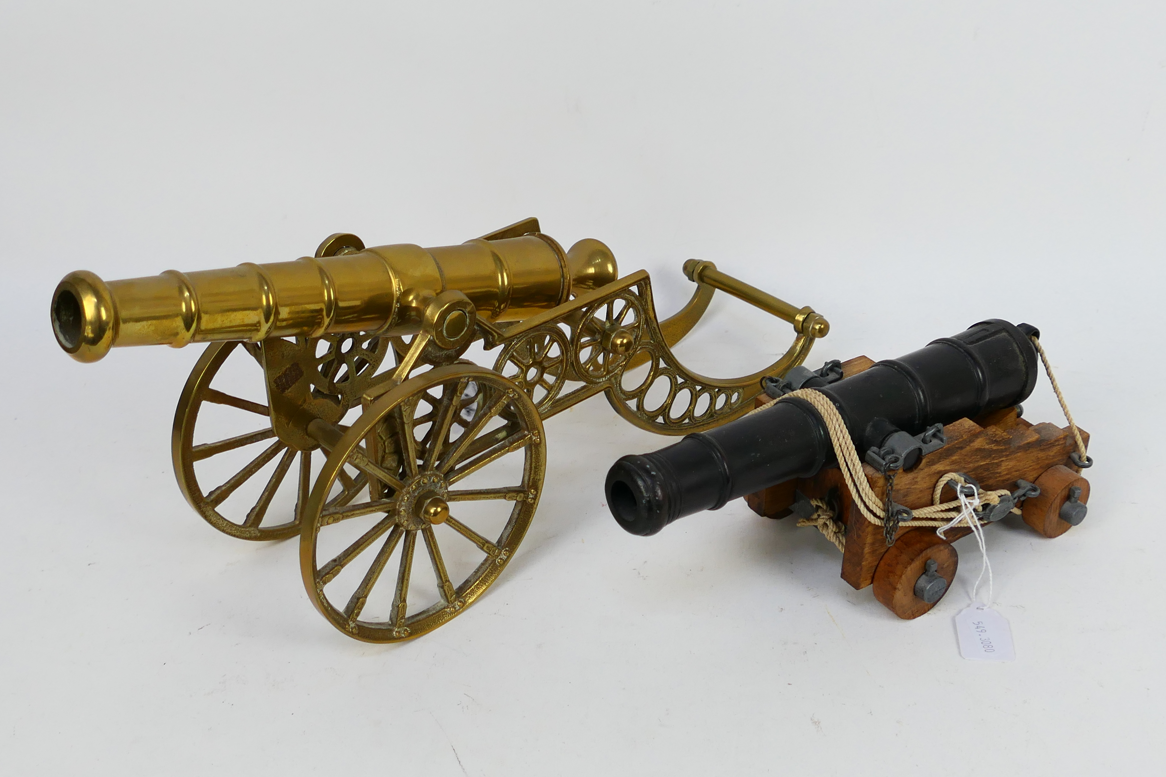 A model canon on wooden carriage and a brass example, largest 42 cm (l). [2].